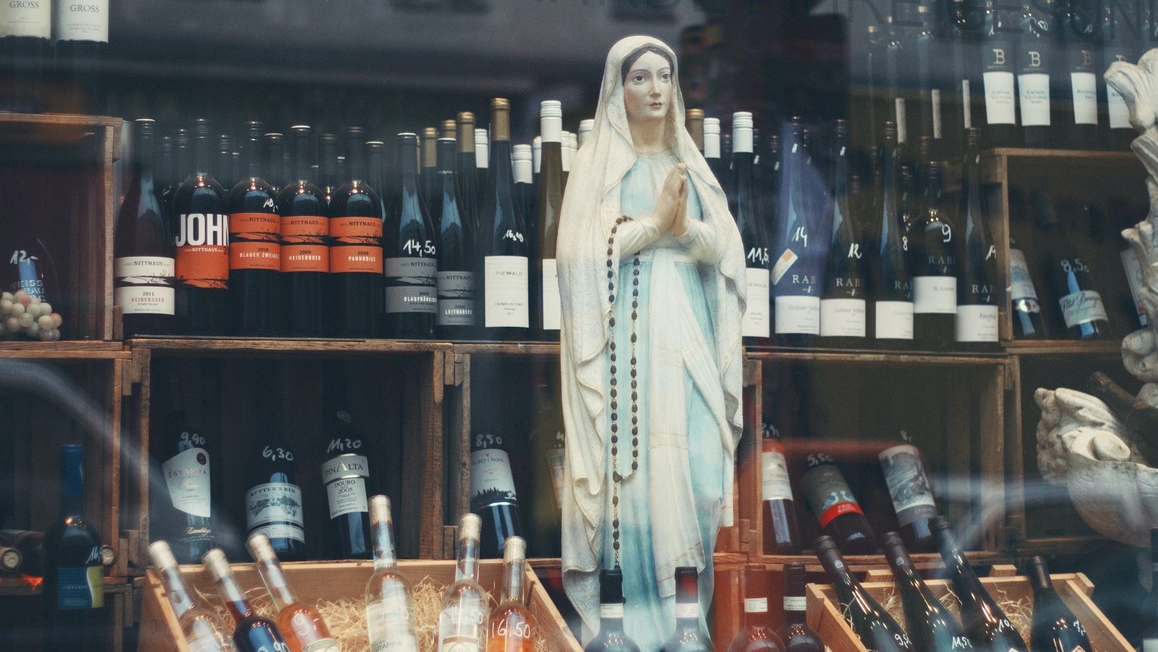 Marienfigur, die im Schaufenster einer Weinhandlung steht